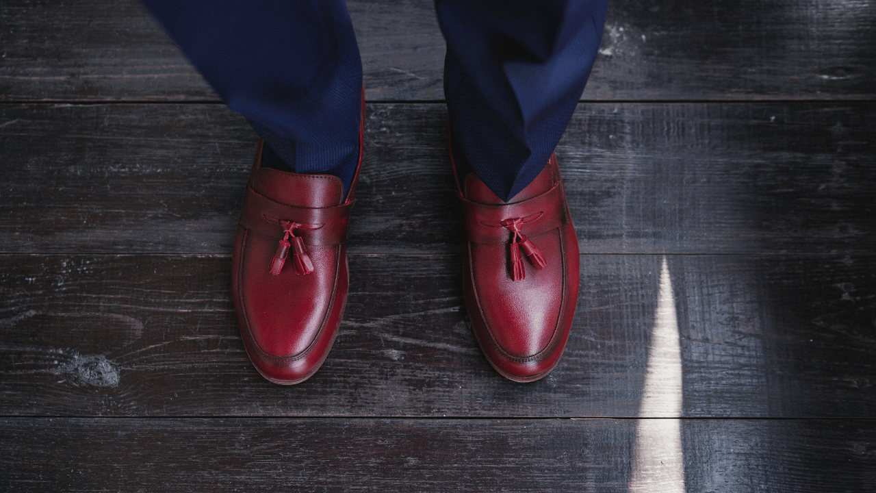 a man wearing burgundy shoes on a navy suit