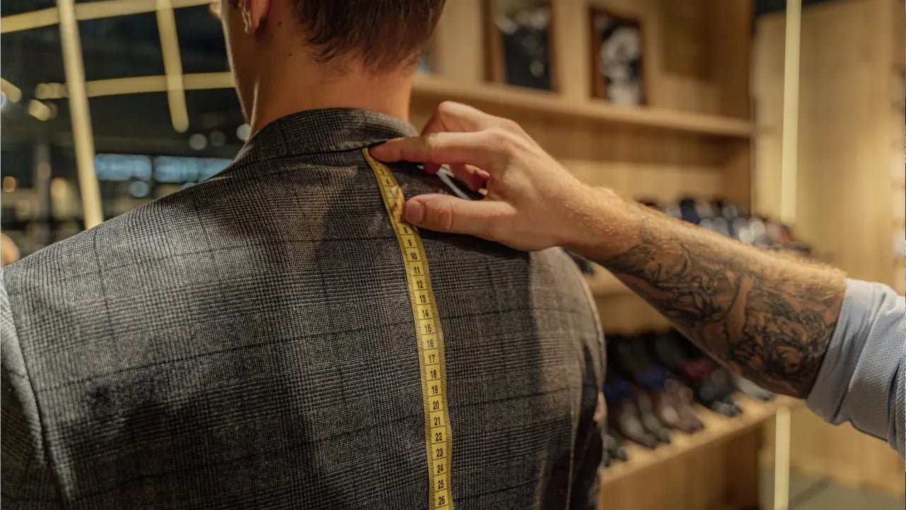 a person measuring the back length for the suit
