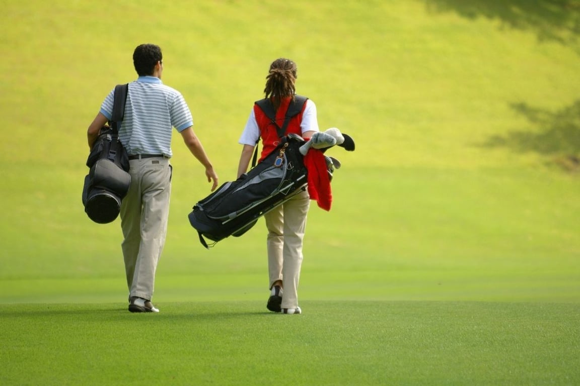 a man and woman walking on a golf course