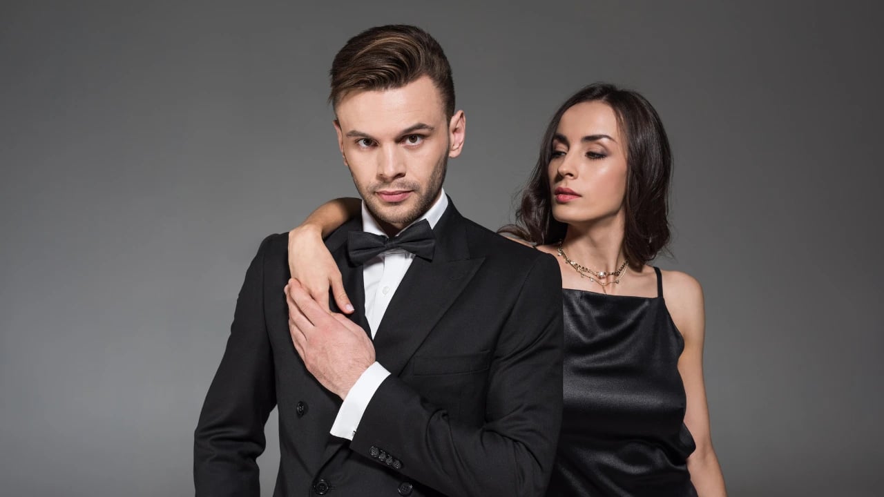 a man wearing a tuxedo and a woman wearin a gown