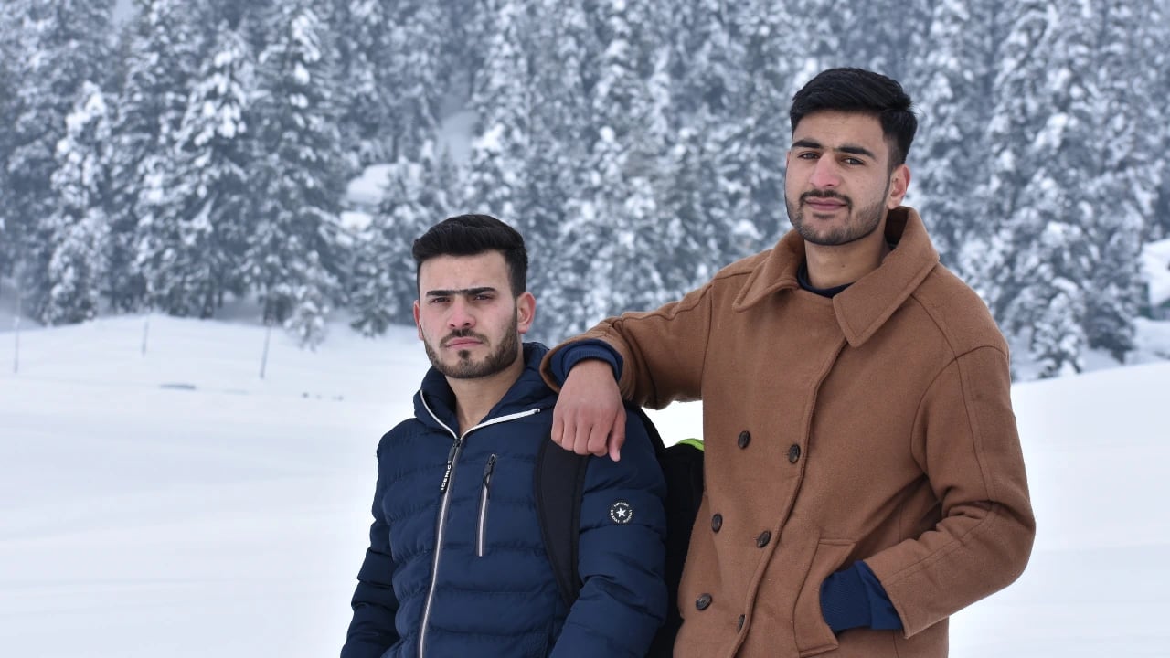 two men in the snow posing for a picture