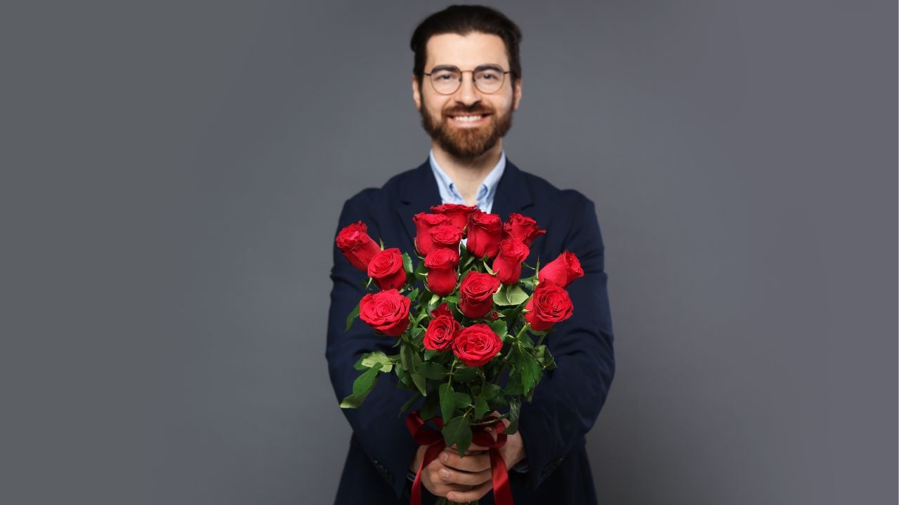 a man in a suit carrying flowers